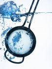 Closeup view of a kitchen sieve in water — Stock Photo