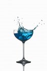 Крупный план синего кюрасао, выплескивающегося из стекла — стоковое фото