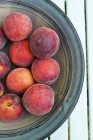 Peaches in brown platter — Stock Photo