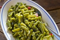 Салат из зеленых бобов с ложкой в миске — стоковое фото