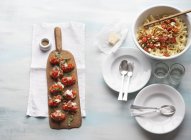 Bruschetta and tagliatelle arrabiata pasta — Stock Photo