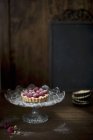 Raspberry tart on glass cake stand — Stock Photo
