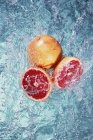 Розовый грейпфрут в воде — стоковое фото