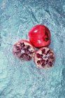 Pomegranate with halves in water — Stock Photo