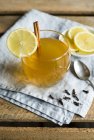 Primo piano vista della bevanda calda toddy con whisky, cannella bastone, chiodi di garofano e fette di limone — Foto stock