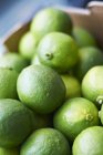 Ripe limes in crate — Stock Photo