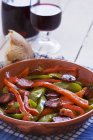Peperoni con chorizo in piatto rosso — Foto stock