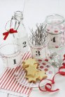 Elevated view of star-shaped cookies with numbered glass vessels — Stock Photo