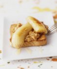 Bananas on toast over plate — Stock Photo