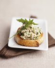 Closeup view of Crostini with chicken and rocket topping — Stock Photo