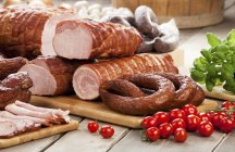 Sausages and ham with cherry tomatoes — Stock Photo