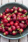 Strawberries in rusic bowl — Stock Photo