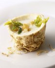 Cream of celeriac soup with croutons in a hollowed-out celeriac on white plate — Stock Photo