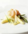 Green and white asparagus with dry-cured ham — Stock Photo