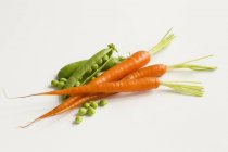 Arvejas y zanahorias frescas - foto de stock