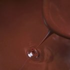 Chocolate sauce dripping from spoon — Stock Photo