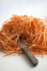 Monte de peelings de cenoura com faca — Fotografia de Stock
