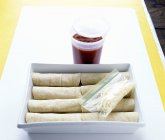 Vista elevada de Enchiladas rellenas en una cazuela con salsa y fideos vegetales - foto de stock