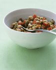 Texas caviar - black-eyed peas with jalapeno, tomato and bell pepper in white plate over green surface — Stock Photo