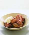 Closeup view of stewed plums with whipped cream — Stock Photo
