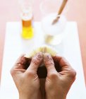 Крупним планом обрізаний вид рук, що чистить тістечко щітка — стокове фото
