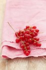 Красная смородина на розовой ткани — стоковое фото