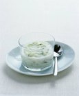 Tzatziki salsa vegetale bianca con cucchiaio su un piatto — Foto stock