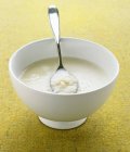 Cauliflower soup in bowl with spoon — Stock Photo