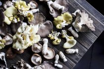 Top view of assorted mushrooms on a rustic wooden board — Stock Photo