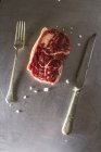 Raw beef steak with knife and fork — Stock Photo