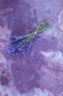 Вид зверху на букет лаванди на фіолетовій поверхні — стокове фото