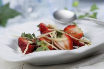 Closeup view of strawberries with vinegar syrup and ginger on plate — Stock Photo