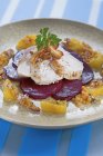 Free-range chicken on beetroot with a lentil and orange vinaigrette on plate over blue surface — Stock Photo