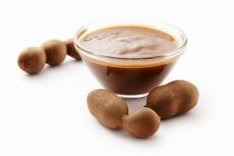 Tamarind concentrate in bowl and tamarinds — Stock Photo