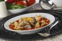 Marmitako - sopa de pescado con patatas, pimientos y tomates en plato blanco - foto de stock