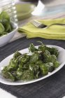 Padron peppers in white plate  over cloth on table — Stock Photo