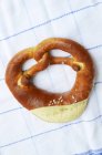 Lye pretzel on a tea towel — Stock Photo