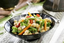 Gemüse, Kichererbsen, grüne Bohnen auf schwarzem Teller über Handtuch — Stockfoto
