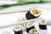 Chopsticks segurando sushi — Fotografia de Stock