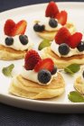 Closeup view of pikelets with cream and berries on platter — Stock Photo