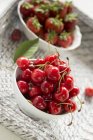 Cherries and strawberries in bowls — Stock Photo
