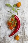 Chilli pepper and orange tomatoes — Stock Photo