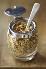 Coarse-grained mustard in jar with spoon — Stock Photo