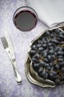 Raisins rouges avec verre de vin rouge — Photo de stock
