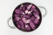 Purple Vitelotte patatas en la sartén - foto de stock