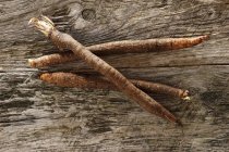 Black salsify on a rustic wooden table — Stock Photo
