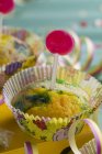 Muffin with green colouring and lollipop — Stock Photo