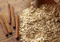 Closeup elevated view of cinnamon sticks and oats — Stock Photo