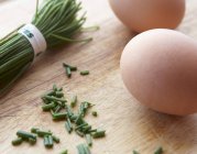 Huevos y cebolletas marrones crudos - foto de stock