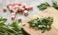 Closeup view of ham cubes and chopped parsley — Stock Photo